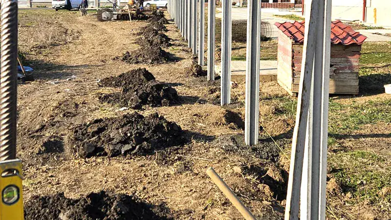 Wykopy i betonowe słupki podczas montażu ogrodzenia