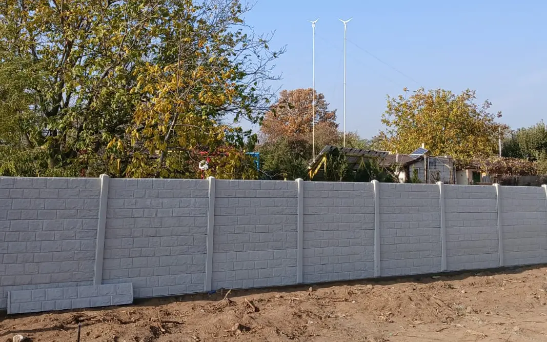 Szare ogrodzenie betonowe z reliefem muru kamiennego